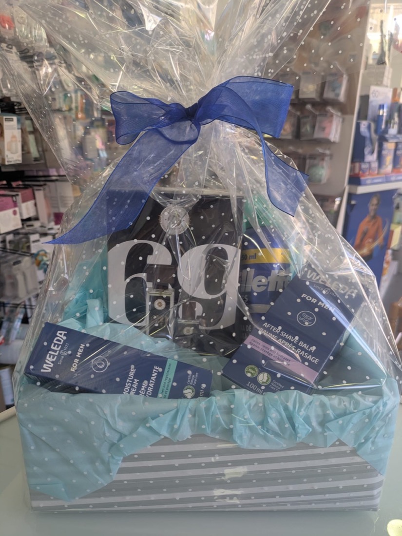 Cesta de regalo con lazo azul y productos Weleda para hombre